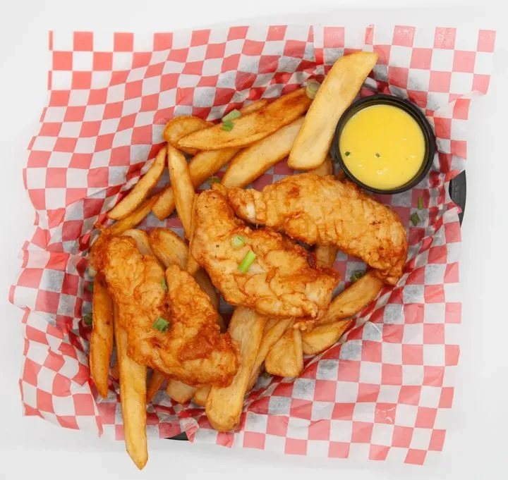 Golden chicken tenders with green onions, fries, and yellow dipping sauce.