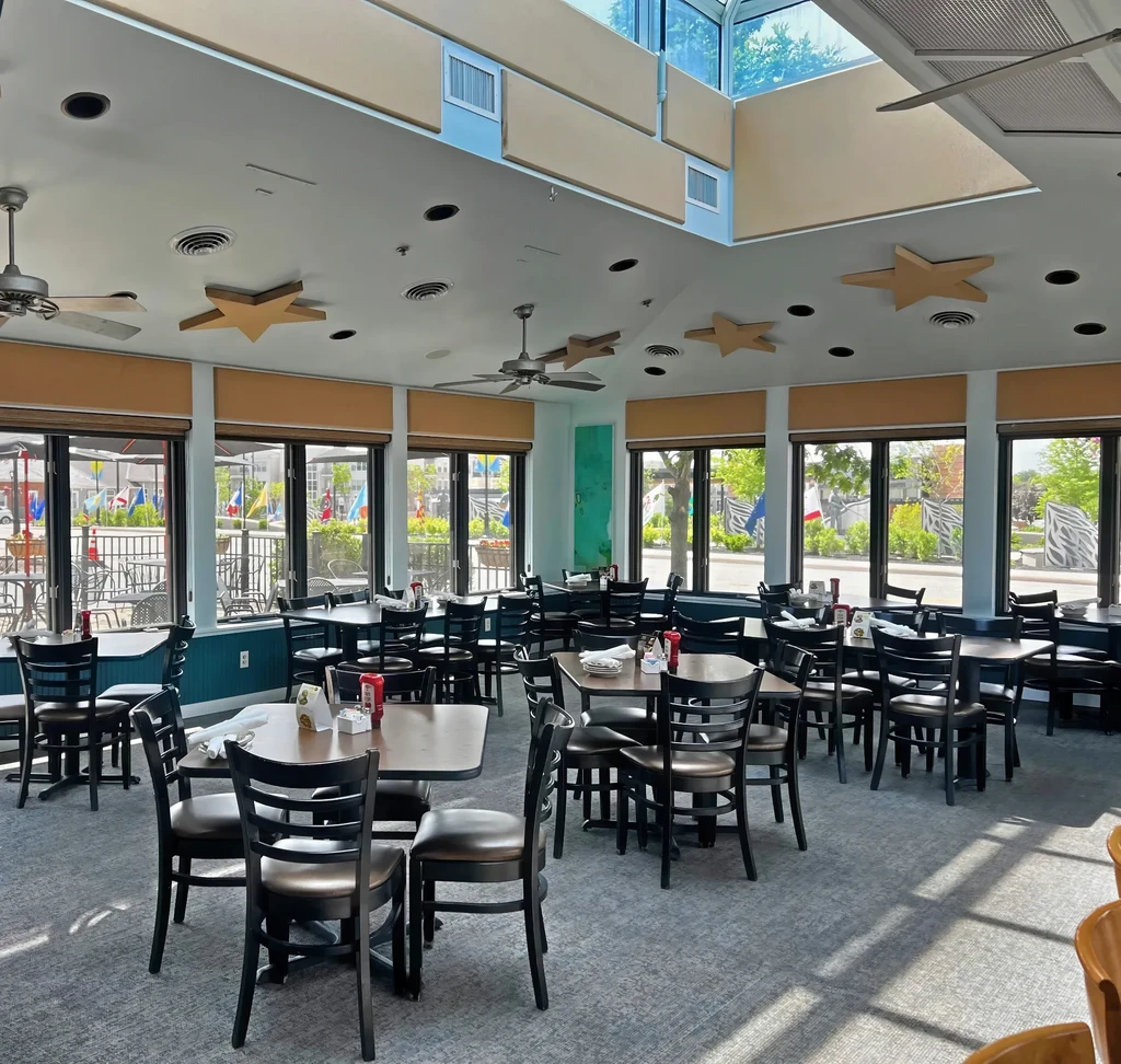 Bright, empty restaurant dining area with tables, chairs, and star decor.