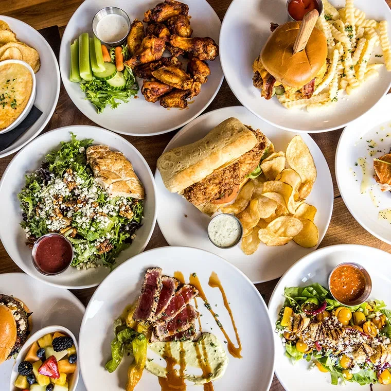 An overhead view of various meticulously prepared dishes on a wooden table.