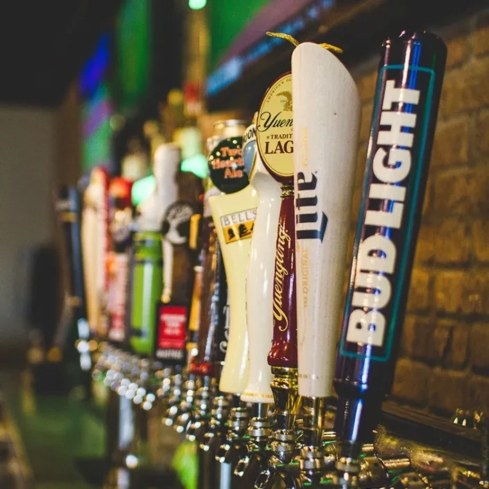 Close-up of beer tap handles: Bud Light, Miller Lite, Yuengling.
