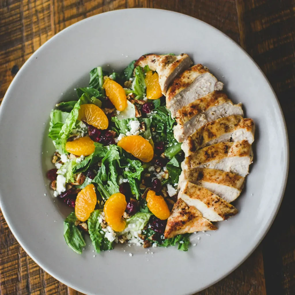 Grilled chicken salad with mandarin oranges, cranberries, cheese, and nuts.
