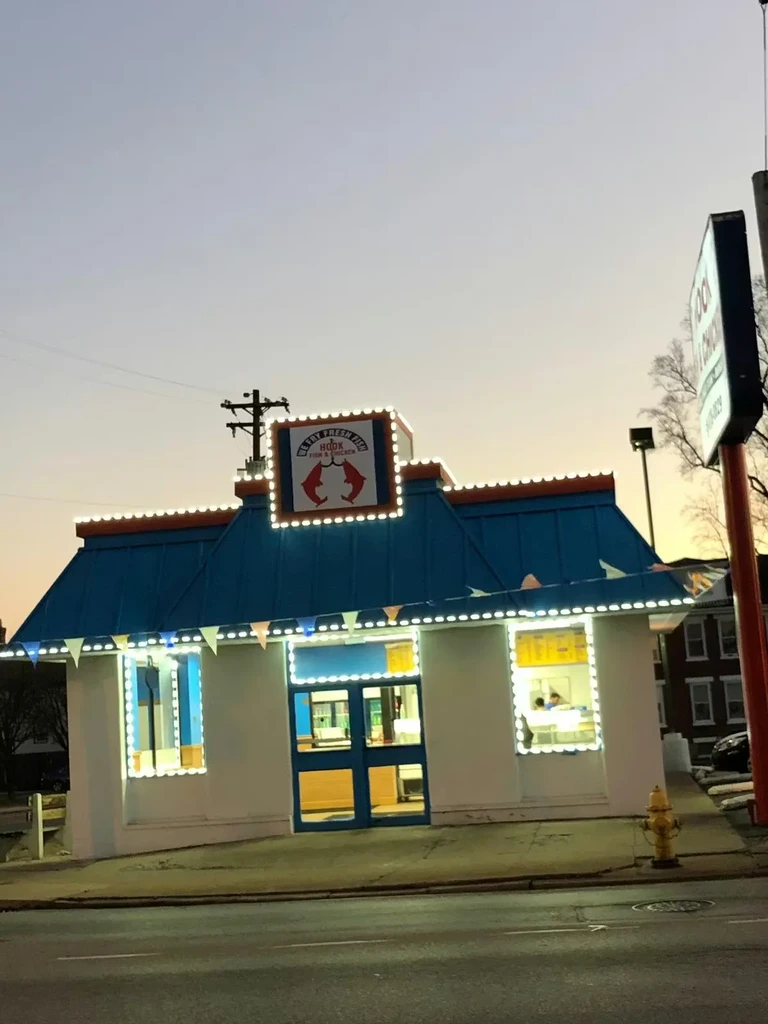 Small restaurant exterior, bright blue roof, white walls, Fresh Fish sign.