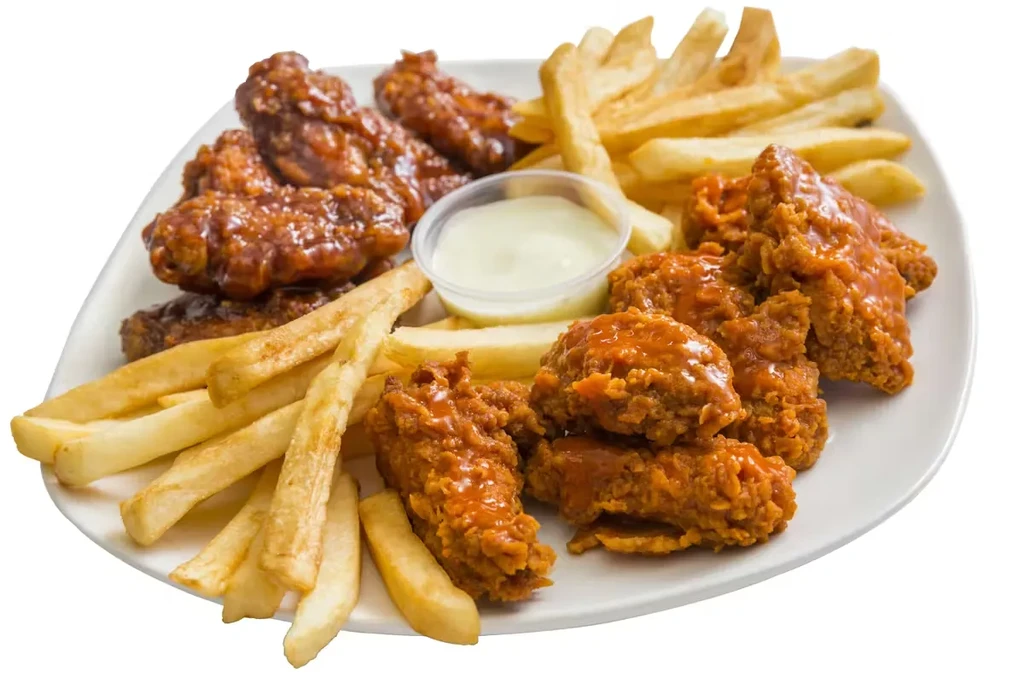 Fried chicken wings, boneless pieces, fries, and dip on a white plate.