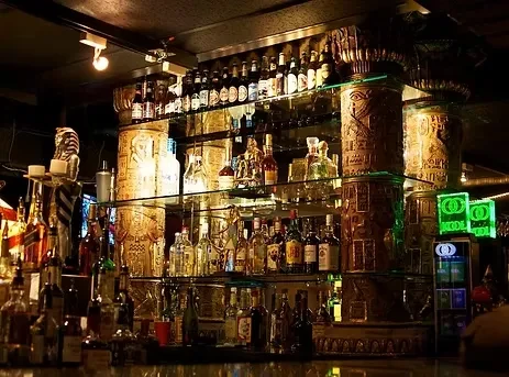 Dimly lit, ornate Egyptian-themed back bar displaying numerous bottles.
