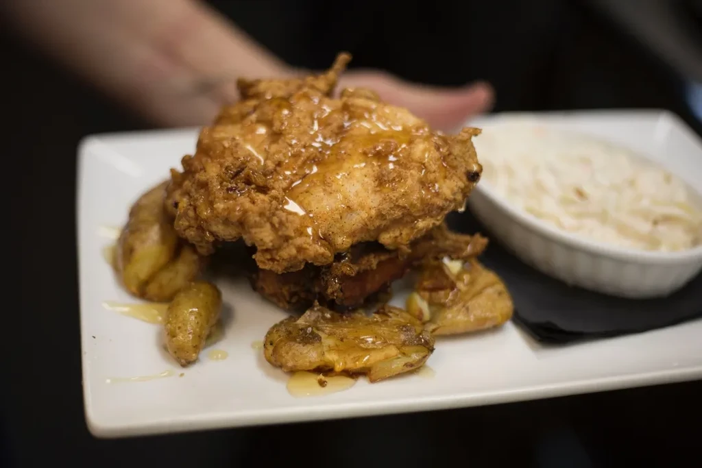 Golden-glazed fried chicken, roasted potatoes, and coleslaw.