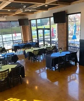 Modern industrial restaurant dining area with set tables and patio view.