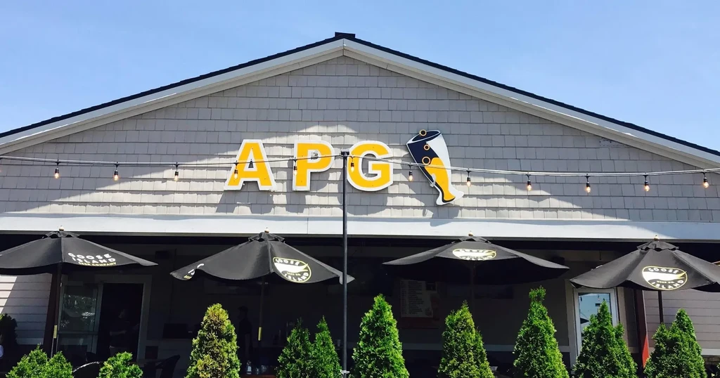 APG building exterior with beer sign, string lights, and Goose Island umbrellas.