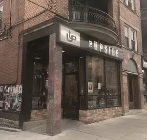 The Upside: Corner brick building with modern sign and large windows.