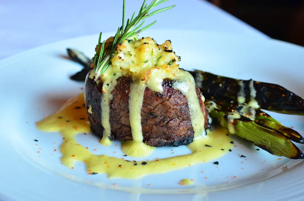 Plated seared beef filet, mashed potatoes, asparagus, creamy sauce.