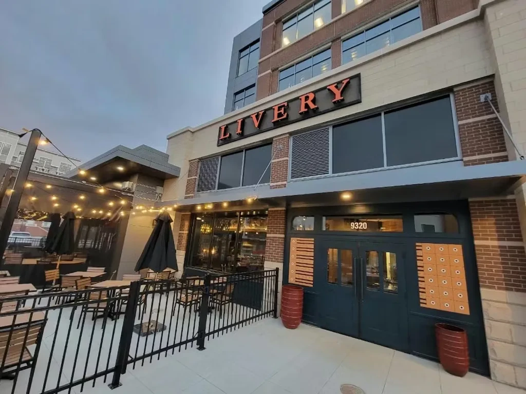 Exterior of Livery restaurant with outdoor patio, string lights, and overcast sky.