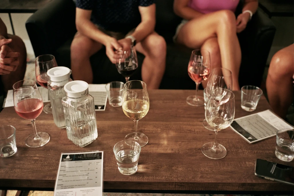 Gathering table with wine glasses, carafes, and a 'Wines' menu.