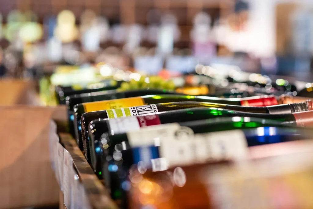 Close-up of horizontal wine bottles in a rack, labels in focus.