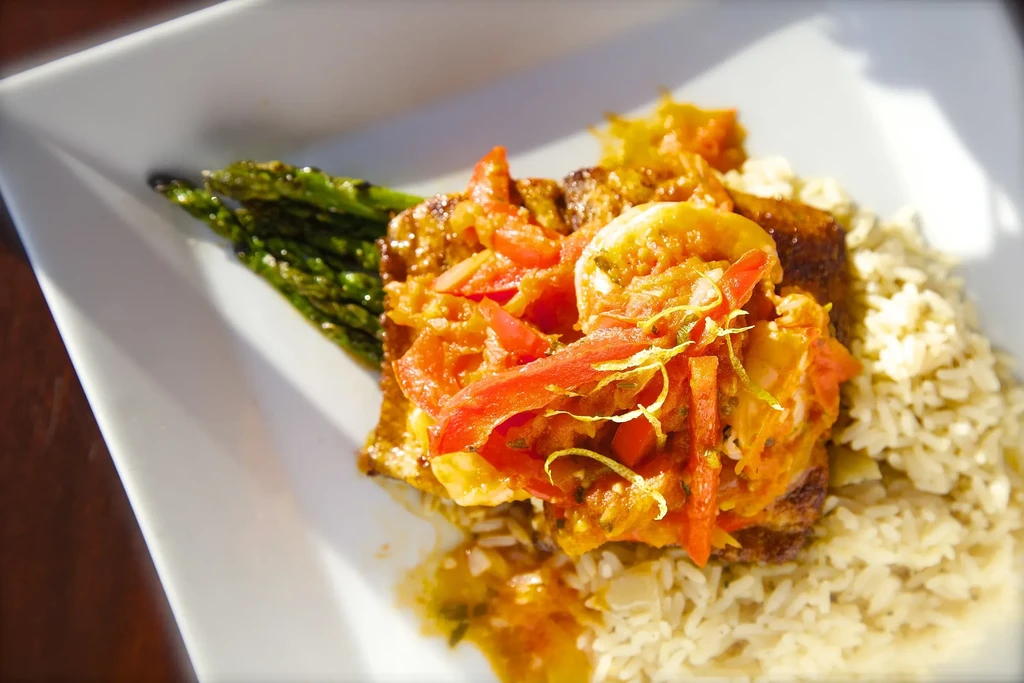 Seared fish topped with shrimp salsa, asparagus, and rice.