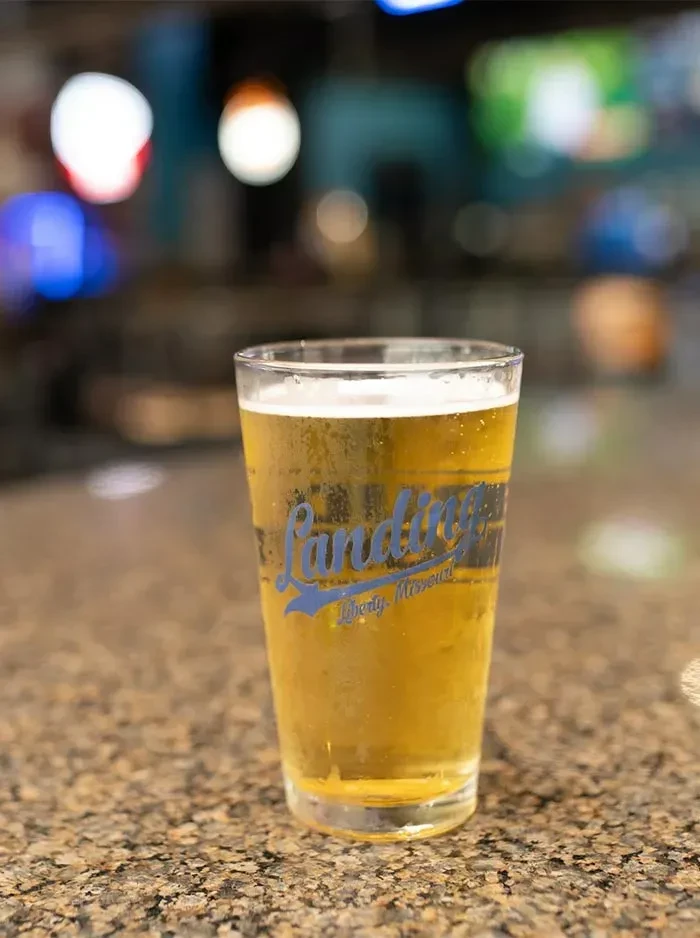 Cold glass of beer with "Landing Liberty, Missouri" on a countertop.