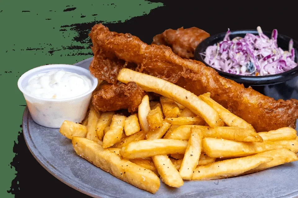 Classic fish and chips with tartar sauce and coleslaw on metal plate.