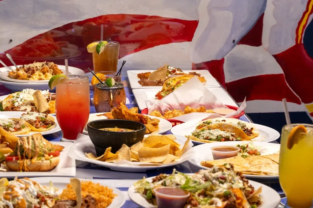 An extensive spread of tacos, nachos, quesadillas, and colorful drinks.