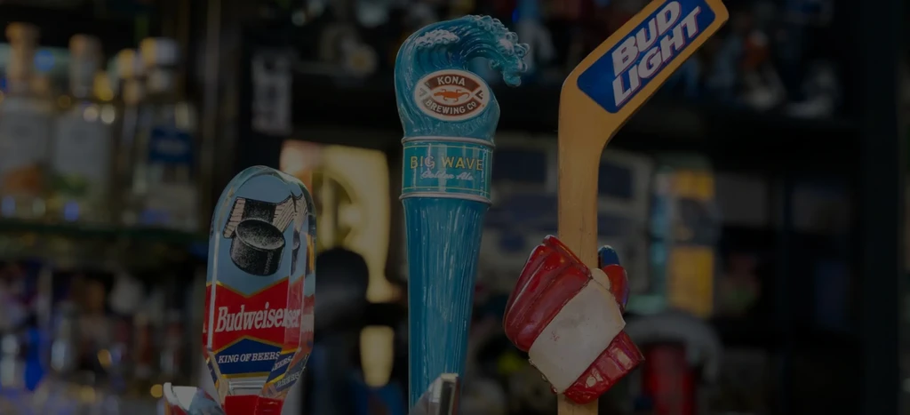 Close-up of three beer tap handles: Budweiser, Kona Big Wave, Bud Light.