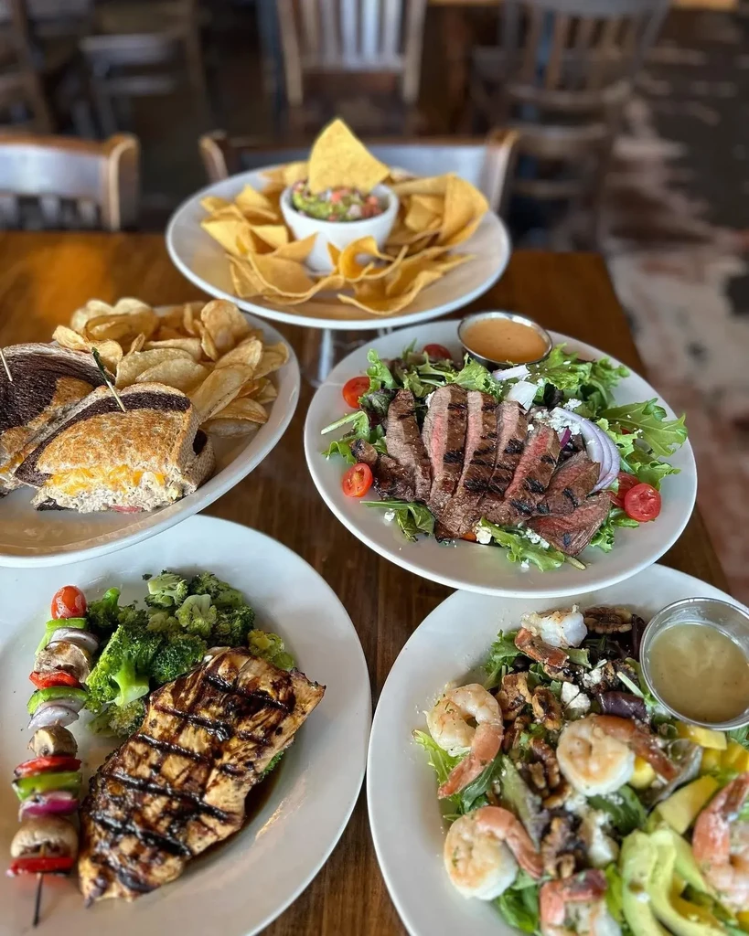 Assortment of colorful dishes and salads on a rustic wooden table.