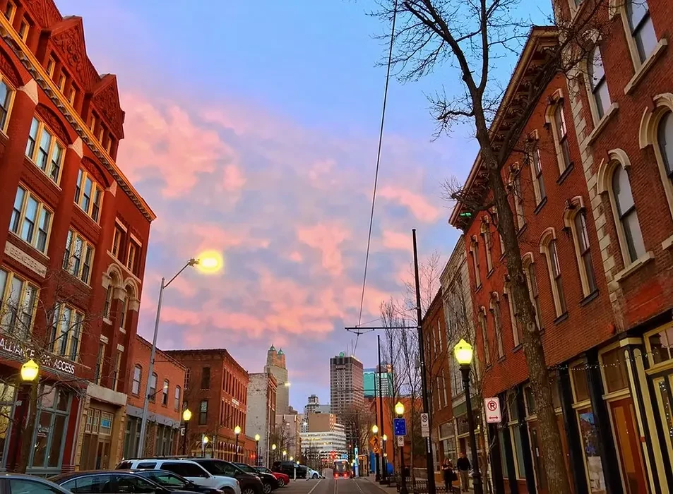 Vibrant twilight cityscape with historic brick buildings and glowing streetlights.