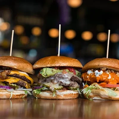 Three gourmet burgers: cheese, guacamole, and buffalo style.