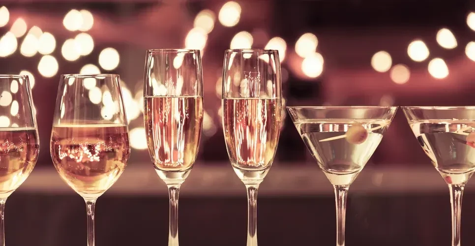 Six glasses of sparkling wine and martinis in a row.