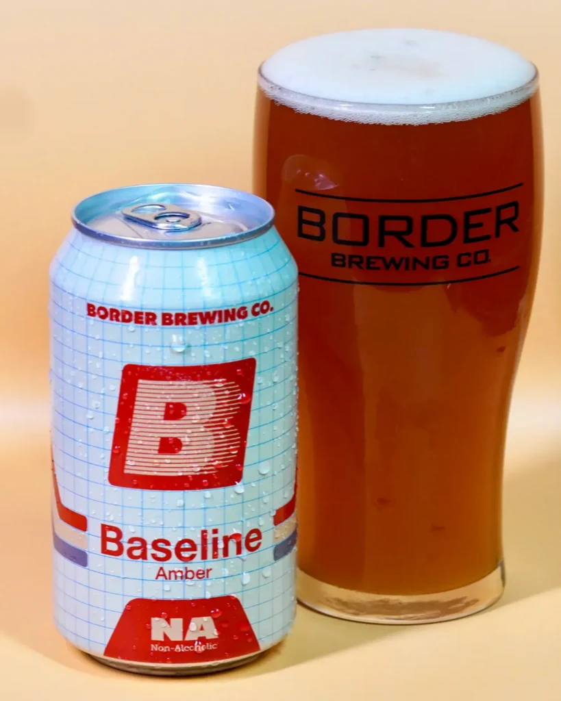 Cold can of Baseline NA beer and a glass of amber brew.
