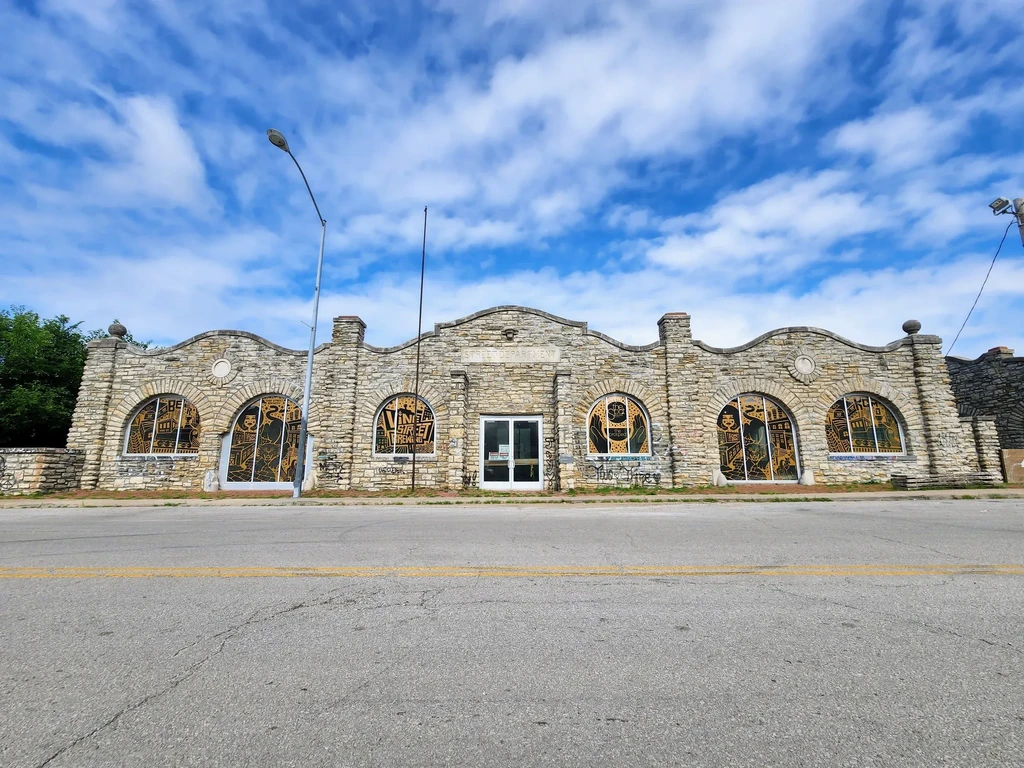 Stone building with ornate window designs including 'BEER' and 'VINYL STREET RECORD'.