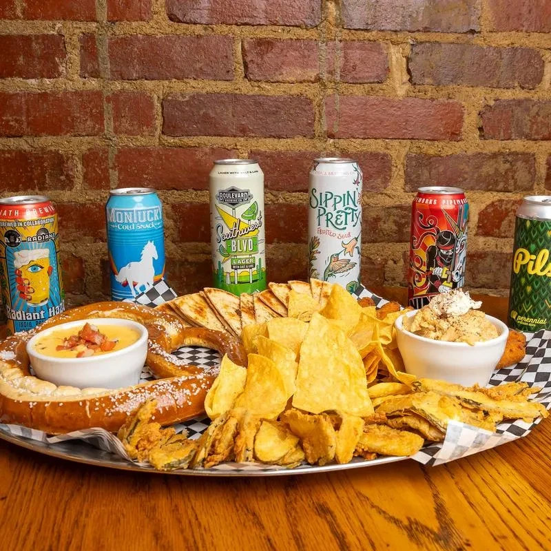 Appetizer platter with pretzel, chips, fried snacks, and six colorful craft beers.