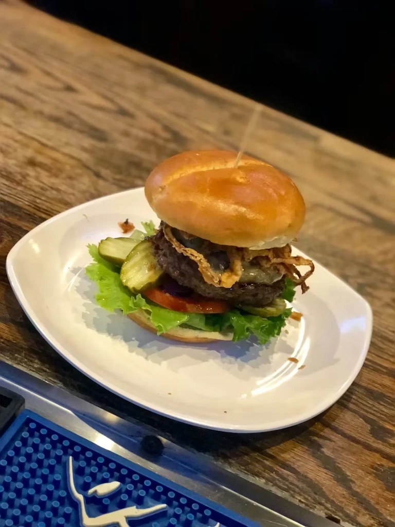 Double cheeseburger with lettuce, tomato, pickles, and crispy onions.