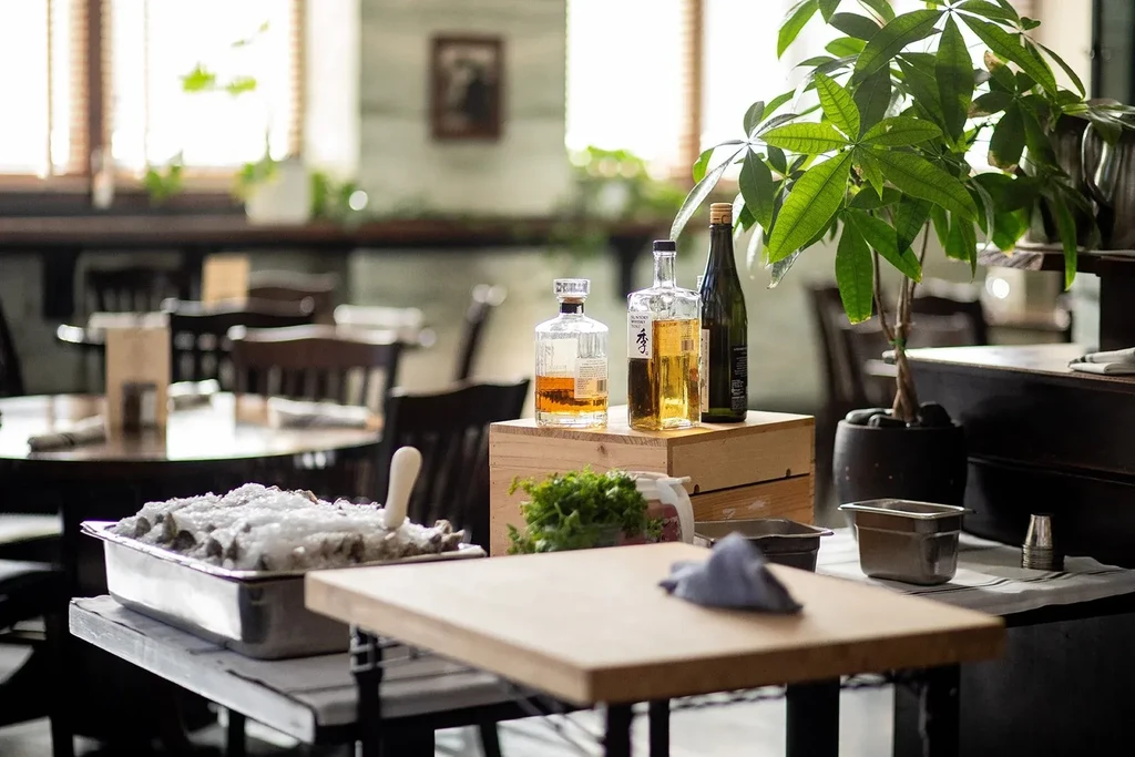 Restaurant service station with oysters on ice, spirits, and fresh herbs.