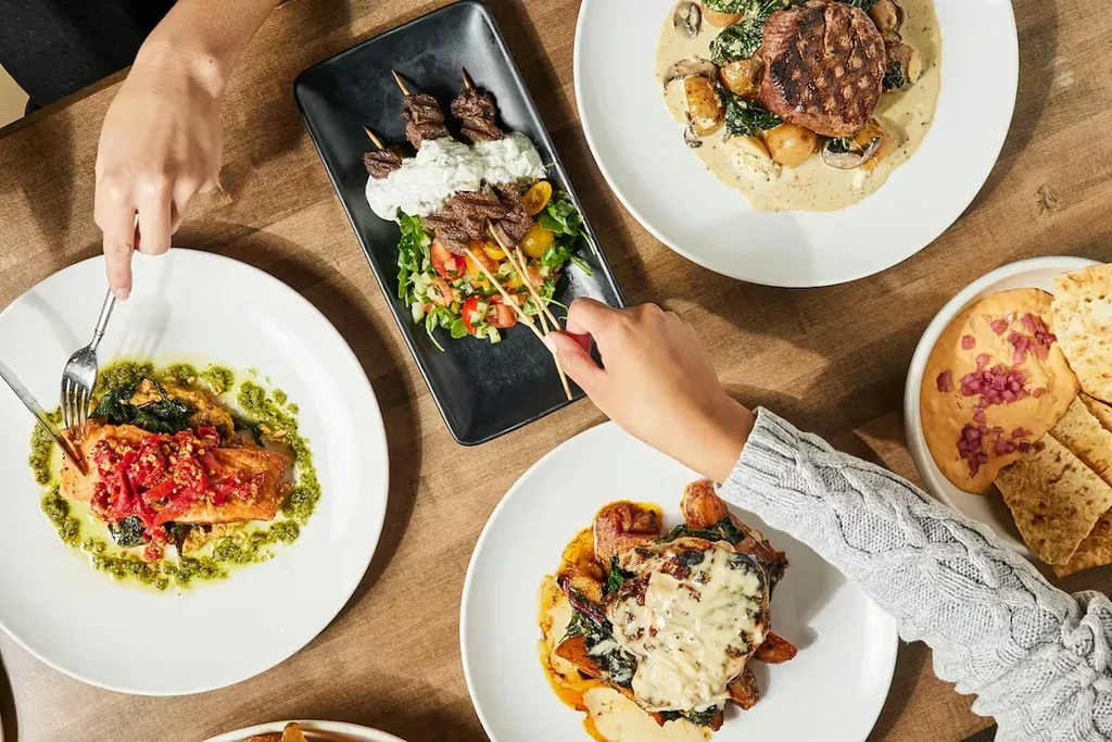 Overhead view: two people sharing a meal of beautifully plated dishes.
