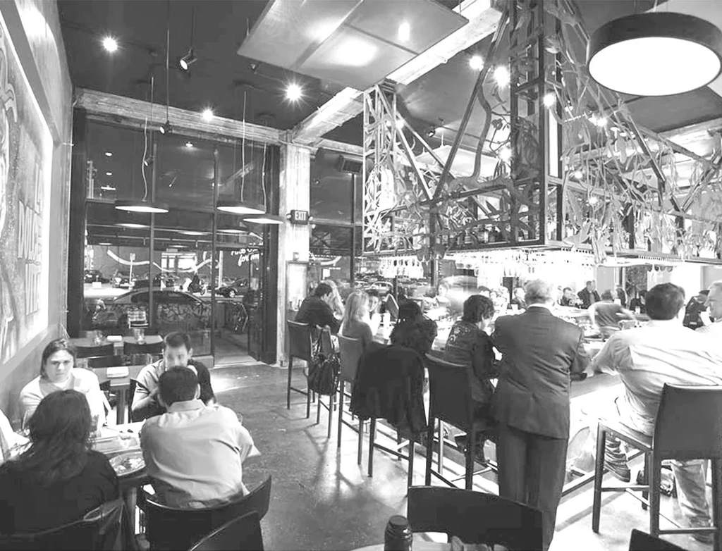Bustling black and white modern industrial restaurant and bar.