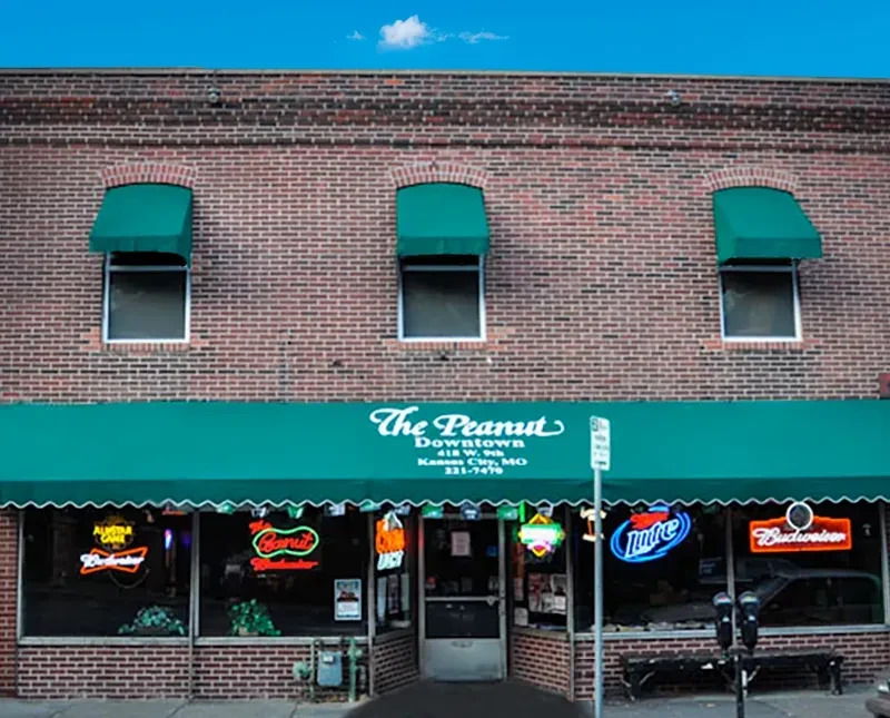 Exterior of two-story brick building with green awnings for The Peanut.