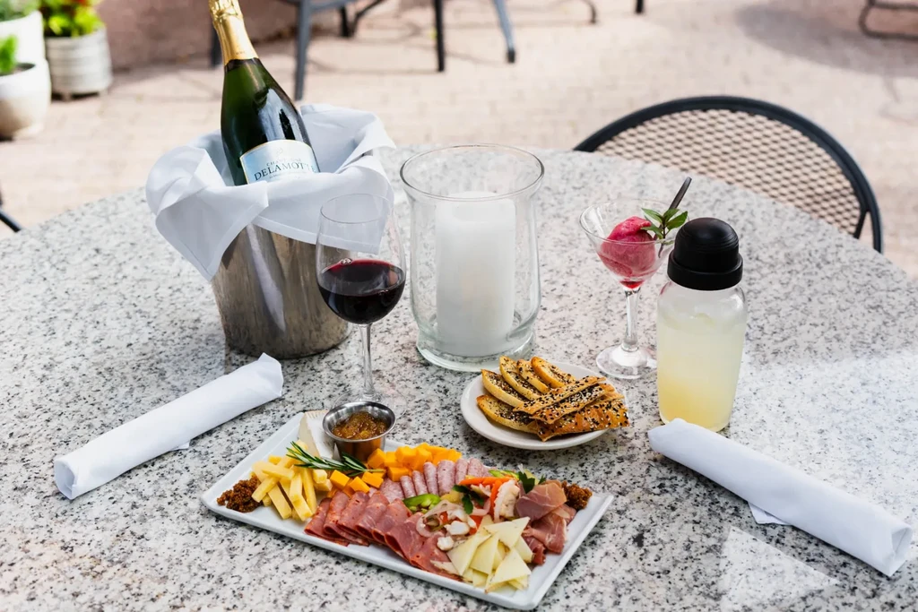 Outdoor restaurant table with charcuterie board, drinks, and sorbet.