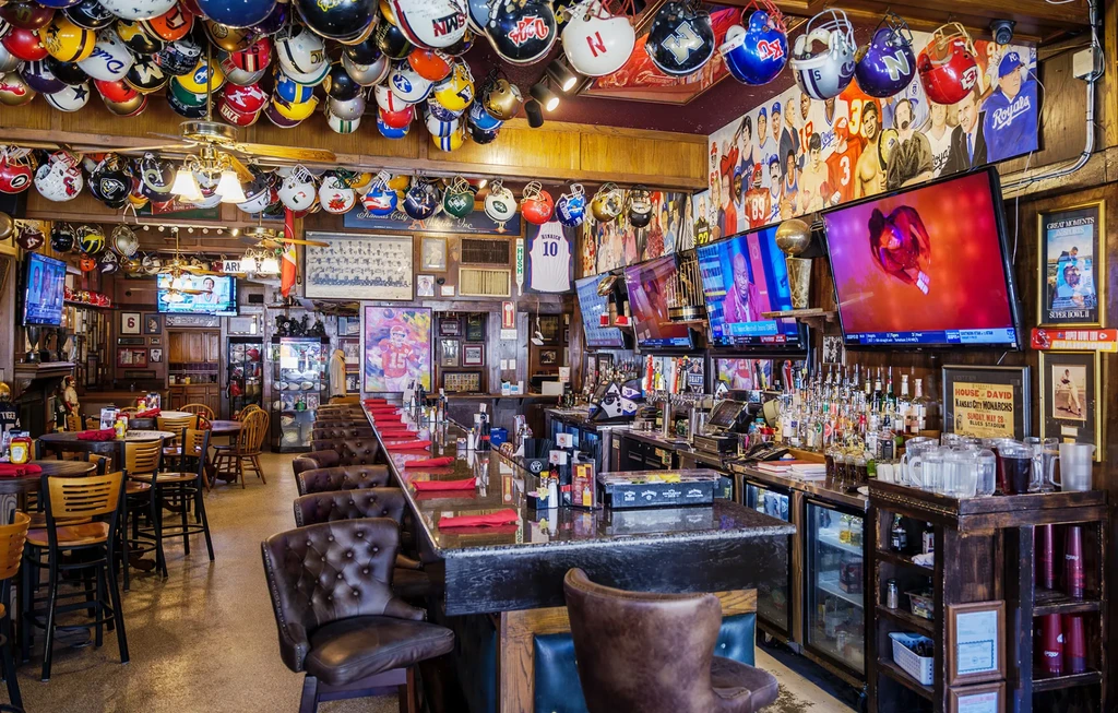 Vibrant sports bar interior with football helmets covering the ceiling.