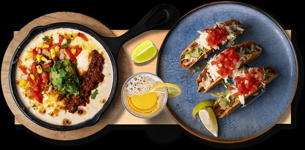 Mexican cheesy dip, crispy tacos, and beer, overhead.