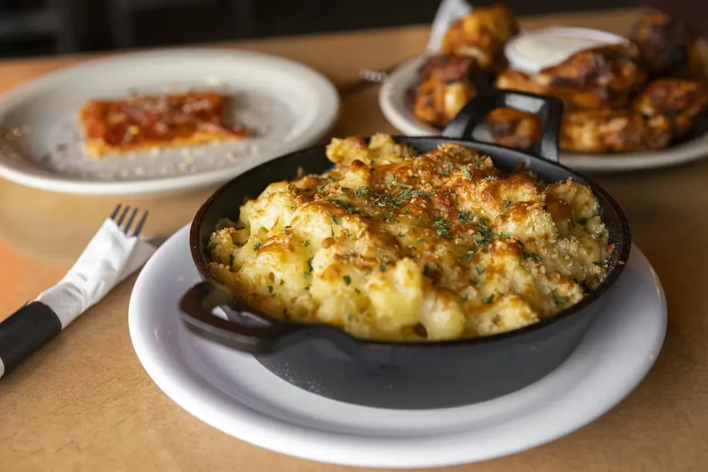 Cast iron baked mac and cheese with golden crust and herbs.