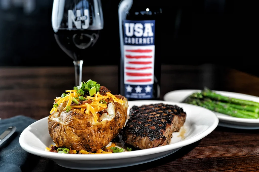 Grilled steak, loaded baked potato, asparagus, and red wine.