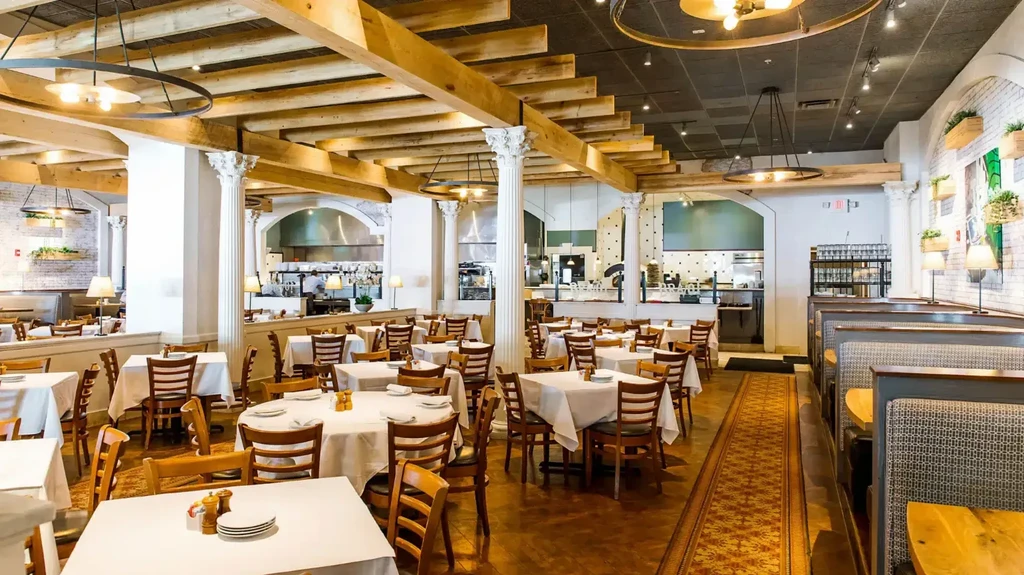 Bright, spacious, rustic-chic restaurant with wooden beams and white tables.