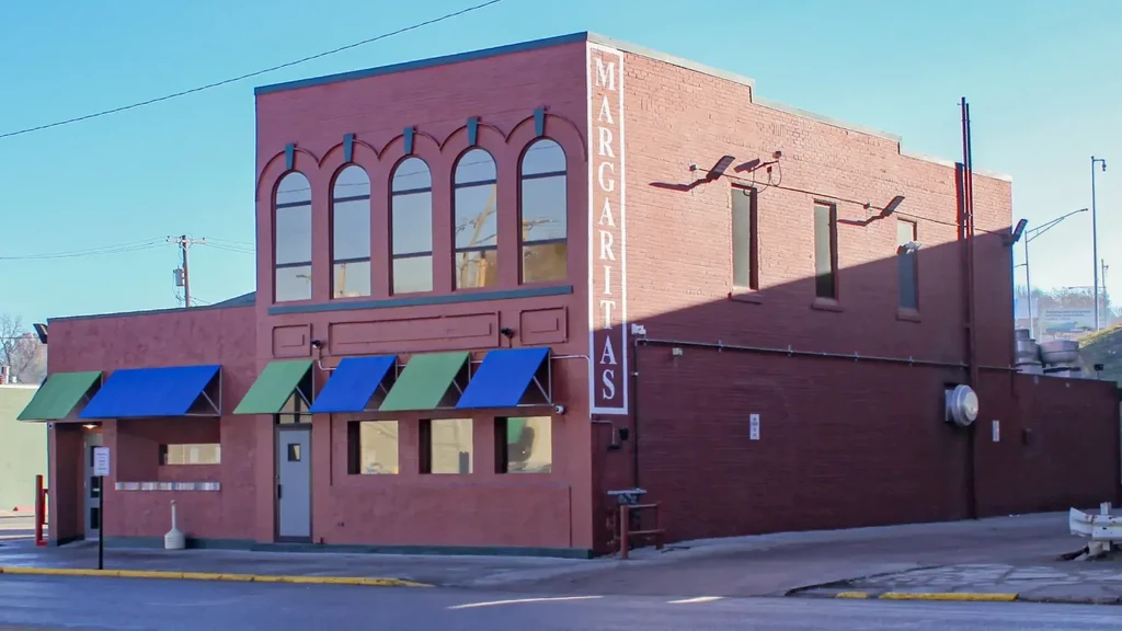 Sunny exterior of Margaritas, a two-story brick restaurant with awnings.