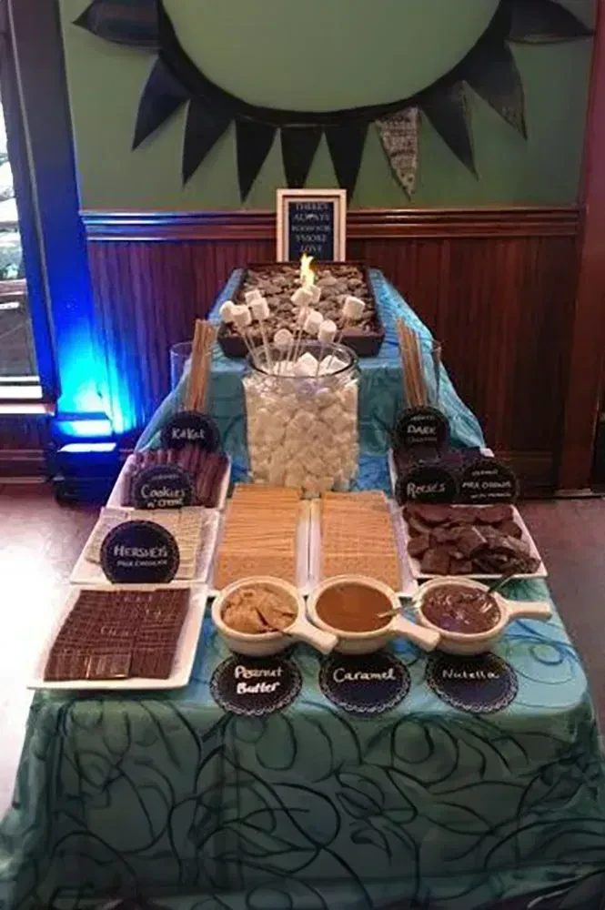 S'mores dessert station with flame, marshmallows, chocolates, and dips.