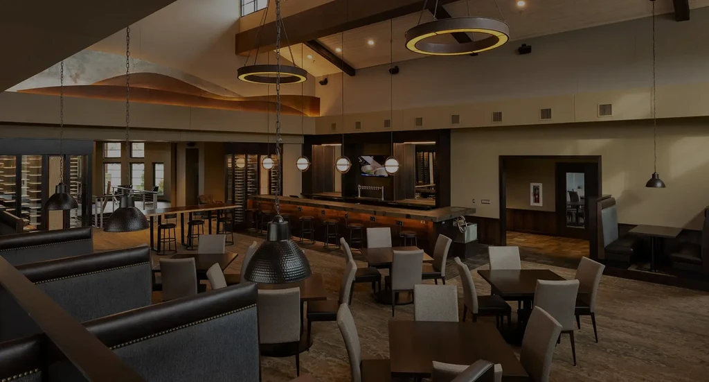 Modern, empty restaurant interior with bar, booths, and unique ceiling features.