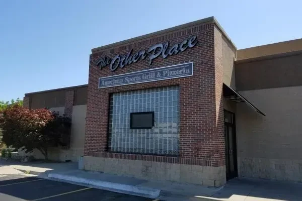 The Other Place restaurant, brick and stucco building with glass block window.