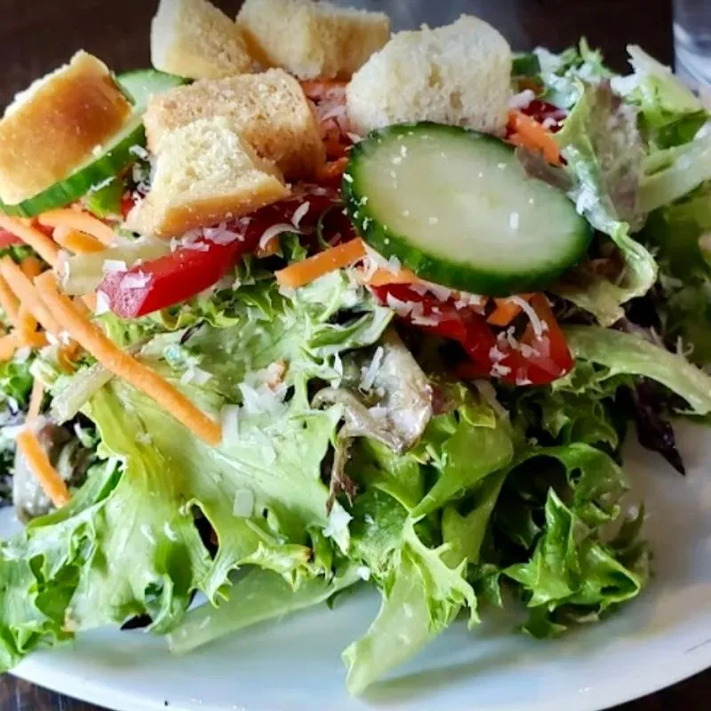 Fresh garden salad with lettuce, cucumber, carrots, peppers, and croutons.