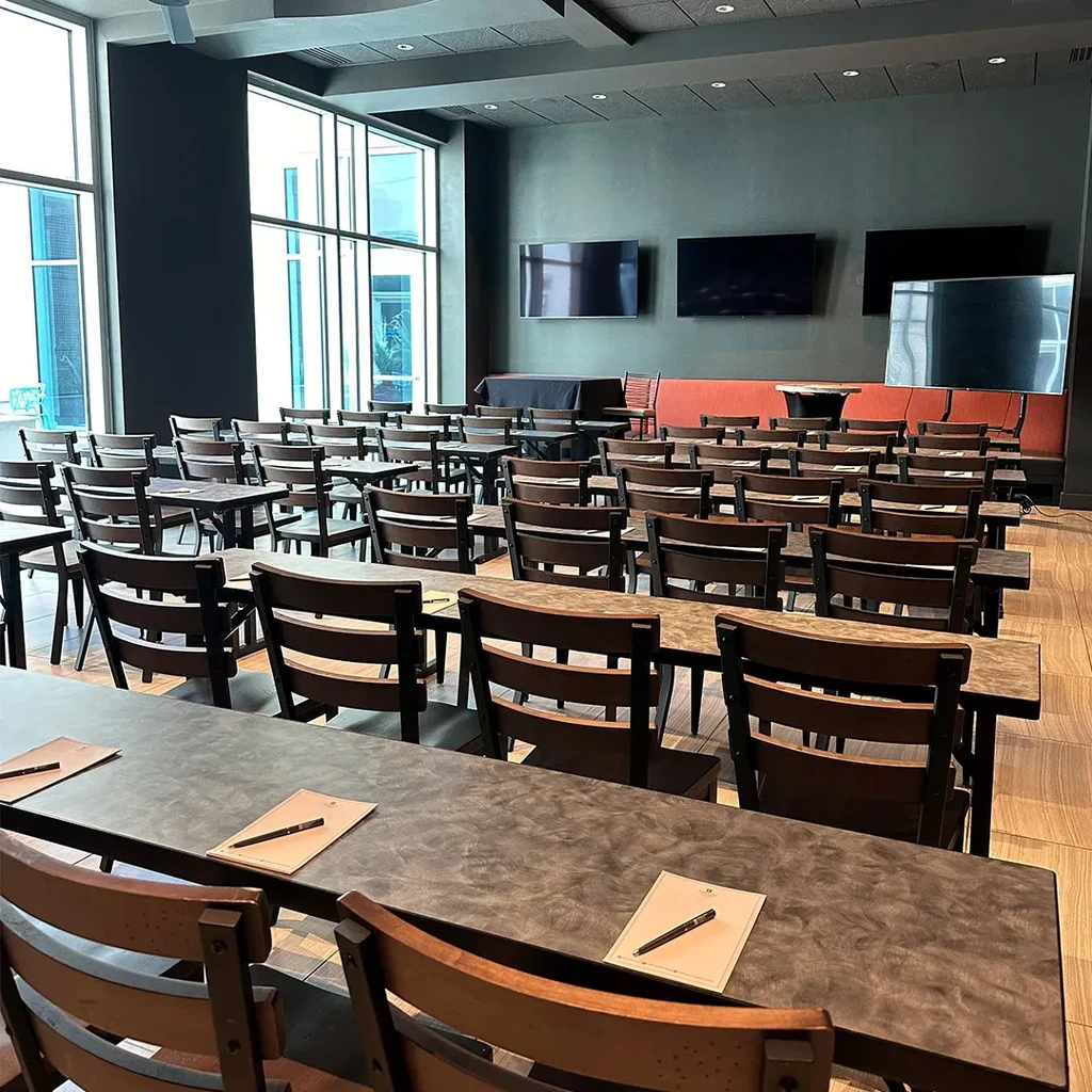 Empty modern conference room, classroom style, with TVs and large windows.