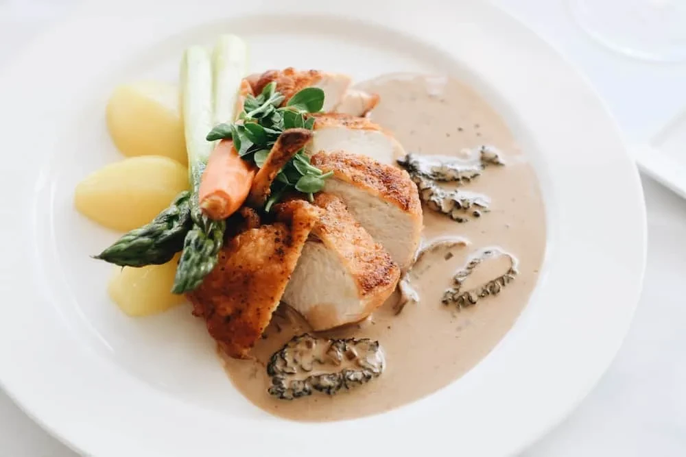Sliced chicken breast, morel sauce, potatoes, asparagus, carrots.