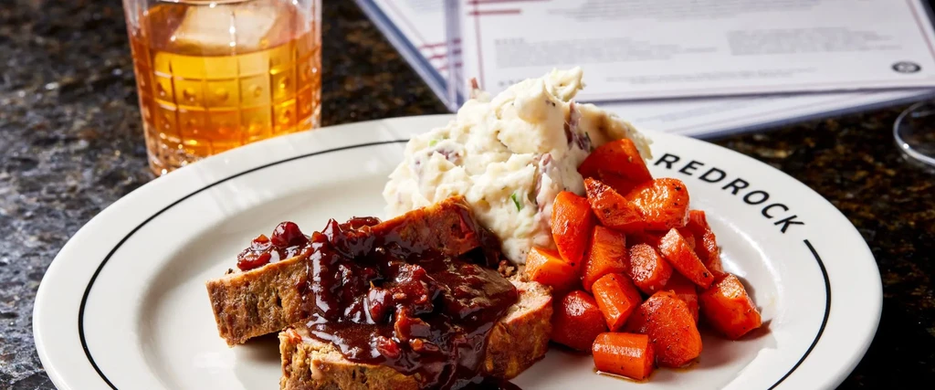 Plated meal: Meatloaf, potatoes, carrots, and drink on a "REDROCK" plate.