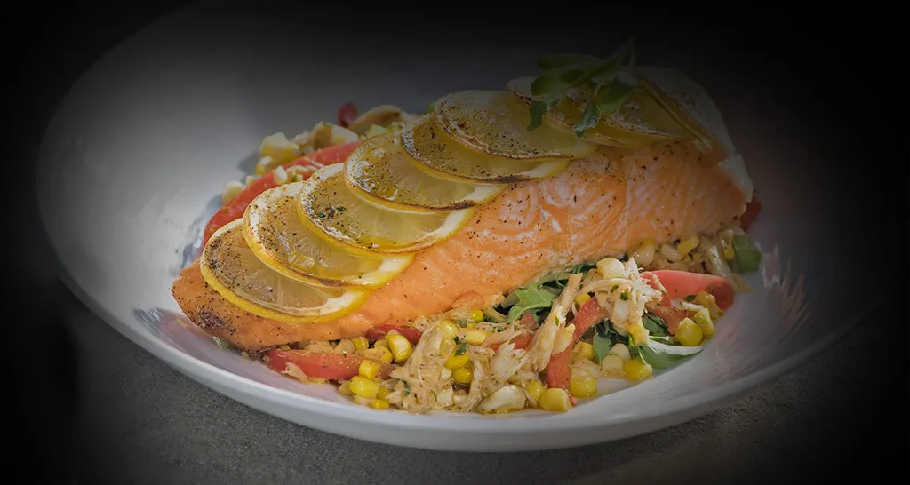 Pan-seared salmon with lemon, herbs, and a corn and vegetable salad.