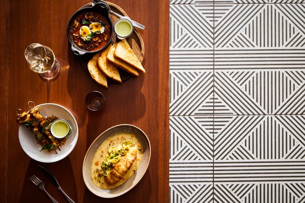 Top-down view of a restaurant table laden with food and drinks.