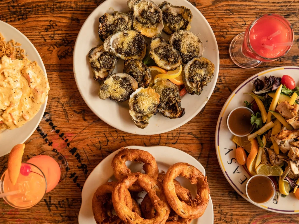 Assorted dishes and drinks on an etched, rustic wooden table.